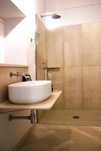 une salle de bain avec un lavabo blanc et une douche dans l'établissement Re Federico Appartamento Deluxe, à Syracuse 7 autres photos