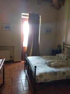 马罗内Agriturismo El Giardì的一间卧室配有床和带窗帘的窗户