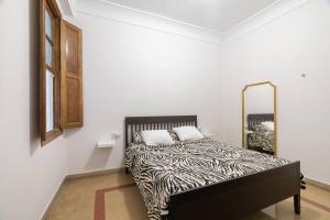 a bedroom with a zebra print bed with a mirror at Casa Bogart Apto 5 dormitorios in Ourense