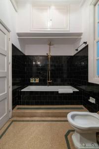 a bathroom with a bath tub and a toilet at Casa Bogart Apto 5 dormitorios in Ourense +8 photos