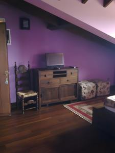 a living room with a wooden dresser and a purple wall at Casona Asturiana Los Gamonales in Logrezana