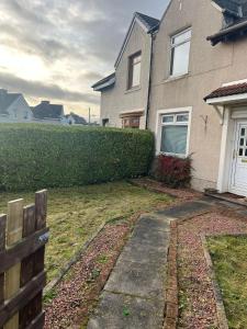 een huis met een heg ervoor bij Rowan in Bellshill