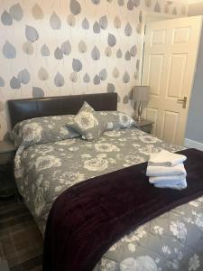 een slaapkamer met een bed met handdoeken erop bij Rowan in Bellshill