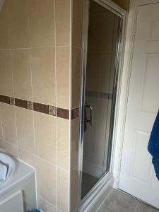 een douche met een glazen deur in een badkamer bij Rowan in Bellshill +1 foto
