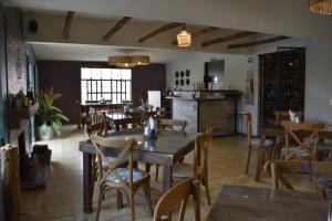 uma sala de jantar com mesas e cadeiras e uma cozinha em Finca del Pomar em Acatlán