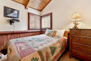 ein Schlafzimmer mit einem Bett, einer Kommode und einem Fernseher in der Unterkunft Bear Tracks Ski Haus Retreat- Hot Tub- Pool Table in Big Bear Lake