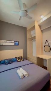 a bedroom with a blue bed with a ceiling fan at K AVENUE B17 house room near airport by Gc in Kota Kinabalu