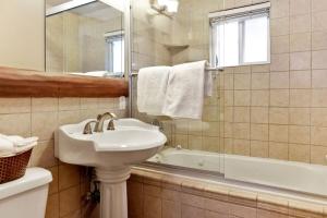 ein weißes Badezimmer mit Waschbecken und Badewanne in der Unterkunft Bear Tracks Ski Haus Retreat- Hot Tub- Pool Table in Big Bear Lake + 10 Fotos