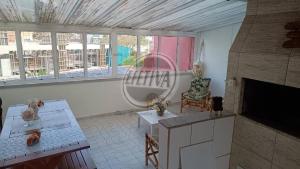 a living room with a fireplace and a chair at Triplex no Centro e Pertinho da Praia in Guaratuba +12 photos