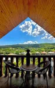 a table and two chairs on a balcony with a view at Guest house marissi in Surami