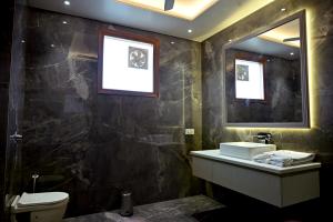 a bathroom with a sink and a toilet and a mirror at FLORENTINO The Luxury Villa in Amritsar +38 photos