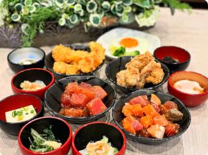 a group of bowls of food on a table at Dormy Inn Oita in Oita