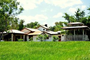 ein Haus mit einem Pavillon im Hof in der Unterkunft Willpattu Wild Watch in Habawewa