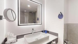 a white bathroom with a sink and a mirror at Radisson Blu Hotel Bremen in Bremen