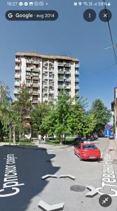 a red car parked in a parking lot with a building at Dunav centar 7 in Smederevo