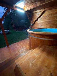 a sauna with a pool in a wooden deck at Cabana Paltini 