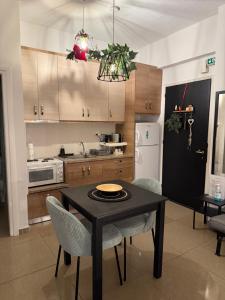 a kitchen with a black table and chairs and a refrigerator at Tiny Square in Nafpaktos +17 photos