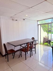a table and chairs in a room with a window at Hotel Urban Guest in Estación La Ermita