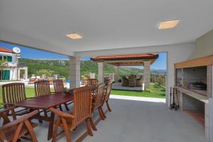 een patio met een houten tafel en stoelen bij Luxury villa with a swimming pool Studenci, Zagora - 18483 in Studenci