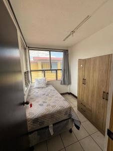a bedroom with a bed and a large window at Hotel Urban Guest in Estación La Ermita