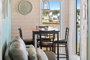 a dining room with a table and chairs and a clock at ONE More Sandy Day - 2BR 2BA Beach Condo, Sleeps 6 in Myrtle Beach