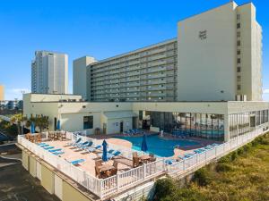 a view of a hotel with a pool and chairs at ONE More Sandy Day - 2BR 2BA Beach Condo, Sleeps 6 in Myrtle Beach