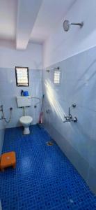 a bathroom with a toilet and a sink and a blue floor at Private Spacious family 1 Bhk Apartment in Arambol in Jāmb