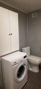 a bathroom with a washing machine and a toilet at Aurora river cabin in Kiruna +10 photos