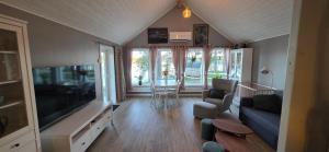 a living room with a tv and a couch and a table at Aurora river cabin in Kiruna