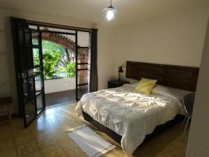 um quarto com uma cama e uma porta aberta em Finca del Pomar em Acatlán