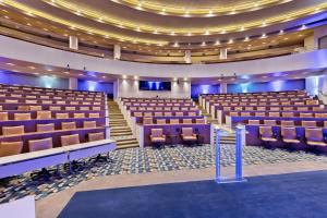 an empty auditorium with purple chairs and purple lighting at Crowne Plaza Princeton - Conference Center by IHG in Princeton +81 photos