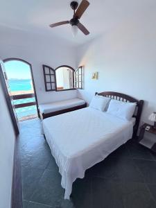 a bedroom with a bed and a ceiling fan at Pousada Vó Nina in Arraial do Cabo +76 photos