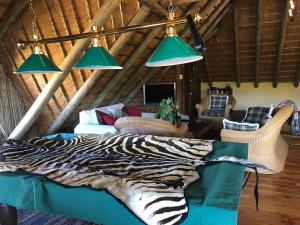 a bedroom with a zebra blanket on a bed at Gunyatoo Trout Trout Farm & Guest Lodge in Sabie