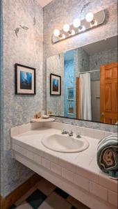 a bathroom with a sink and a large mirror at Thurston House Inn in Ocracoke