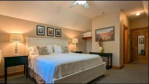 a bedroom with a white bed and two tables with lamps at Thurston House Inn in Ocracoke