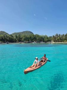 two people sitting on a kayak in the water at Cabugao guest house in El Nido
