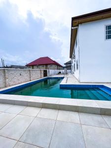 ein großes Schwimmbad neben einem Gebäude in der Unterkunft The Glisson Residence, Adenta in Santeo