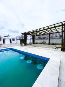 einen Pool mit blauem Wasser vor einem Haus in der Unterkunft The Glisson Residence, Adenta in Santeo