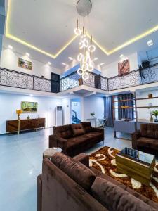 ein großes Wohnzimmer mit Sofas und einem Kronleuchter in der Unterkunft The Glisson Residence, Adenta in Santeo