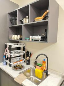a kitchen sink with a dish drying rack above it at Studio near JKIA and SGR Syokimau in Nairobi