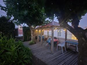 a deck with a gazebo and a table and chairs at Pés Verdes-Alojamento e Chá in Ponta Delgada