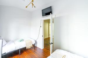 Zimmer mit 2 Betten und einem TV an der Wand in der Unterkunft Jungle House Chillicothe Sleeps 24 Downtown Ohio Free Parking - Walk to Historic District - 5BR Luxury Home - Pet Friendly - King Beds - Over 5,800 Five Star Stays in Chillicothe