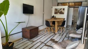 a living room with a table and a tv on the wall at Espacio Inn zona Kempes in Córdoba