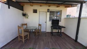 a patio with a table and chairs and a television at Espacio Inn zona Kempes in Córdoba +2 photos