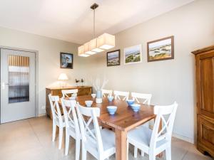 ein Esszimmer mit einem Holztisch und weißen Stühlen in der Unterkunft Argenteuil eerste in Galopen