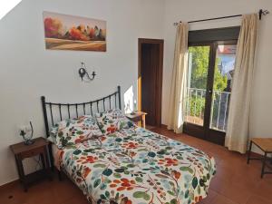 a bedroom with a bed with a colorful comforter at La Libélula de Valles in Puebla de Vallés