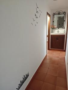 a hallway with a bathroom with a sink and a mirror at La Libélula de Valles in Puebla de Vallés +18 photos