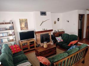 a living room with two couches and a television at La Libélula de Valles in Puebla de Vallés