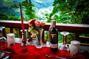 a table with a bottle of wine and flowers on it at El Toro en Bicicleta in San Miguel de los Bancos