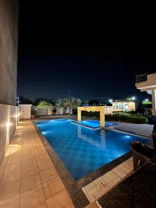 a swimming pool at night with the lights on at The Starlight Farmstay- Poolside Tent Stay in Jaipur in Jāmb